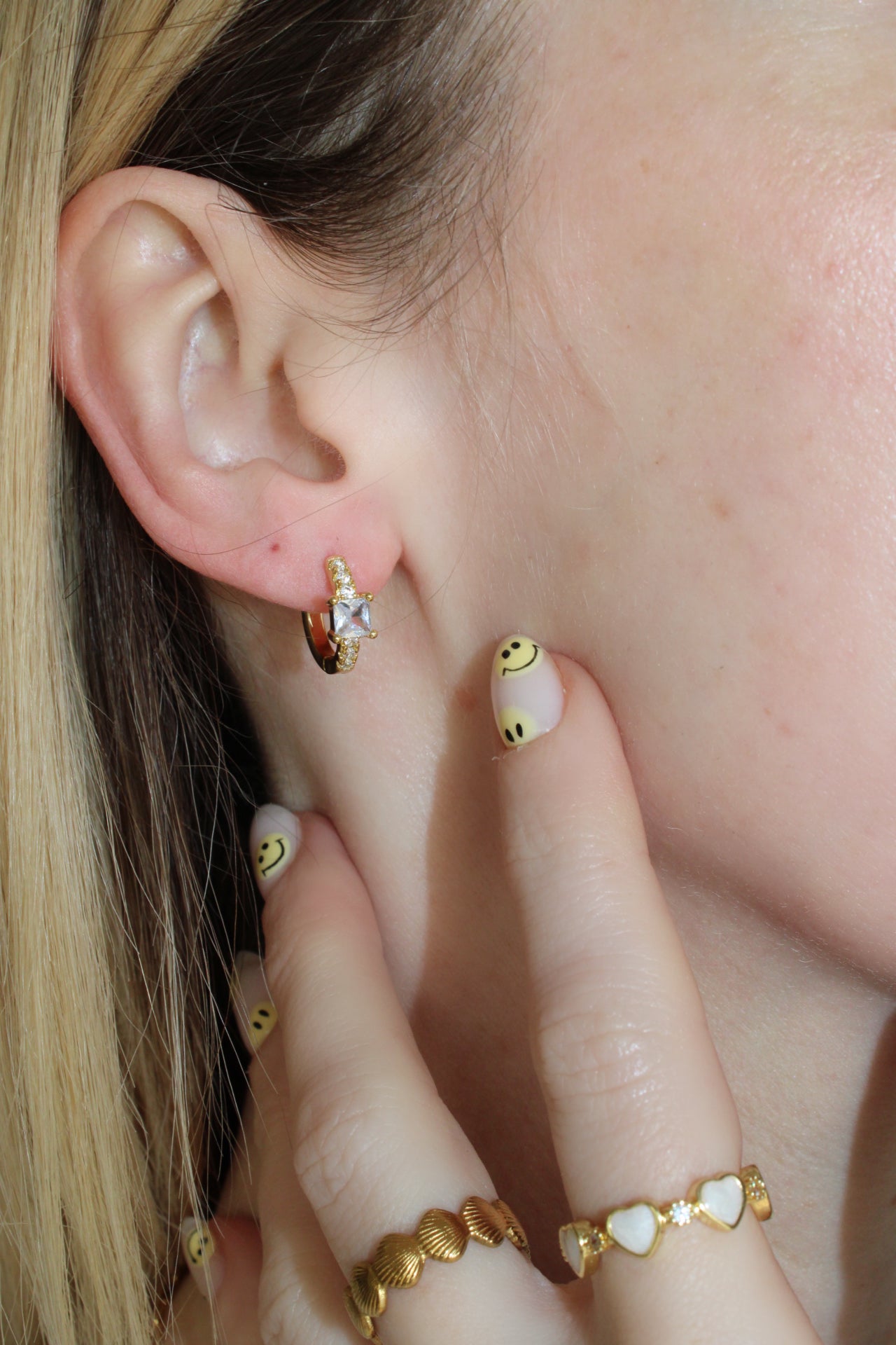 real 18k gold plated small Huggies with square central cubic zirconia at the centre of the earrings, and mini cubic zirconias surrounding it.